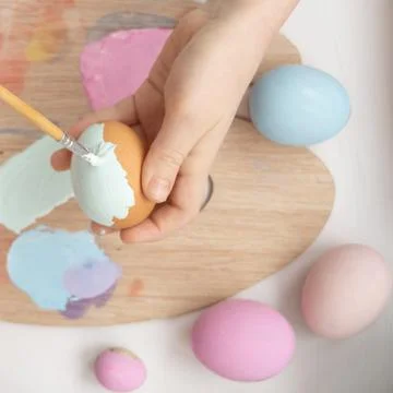 Preparation for Easter. The child is holding a large egg in his hands. Pastel Stock Photos