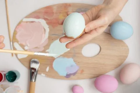 Preparation for Easter. The child is holding a large egg in his hands. Pastel Stock Photos