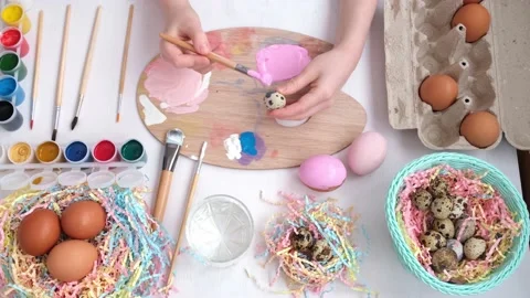 Preparation for Easter. The child picks up a small quail egg and paints it Stock Footage 171889019