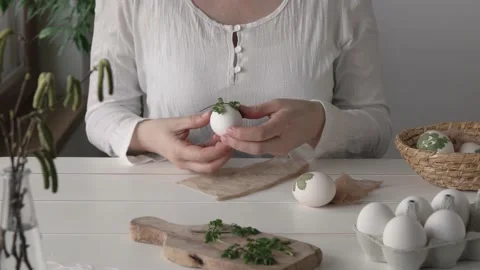 Preparation of Easter eggs for dyeing with onion peels with a pattern of herbs Stock Footage 169890678