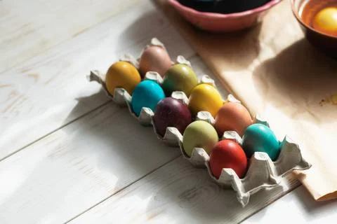Preparation for Easter. Naturally dyed Easter eggs in egg carton on kitchen Stock Photos