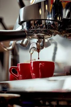 Preparation of espresso in a coffee machine. A drop of coffee falls into th.. Foto stock
