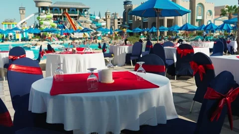 Preparation of festive tables for evening dinner by the hotel pool. Stockbeeldmateriaal 347764347