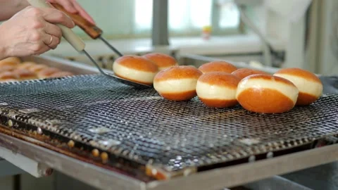 Preparation of fresh fried doughnuts with stuffing at the production factory Stock Footage 171891533