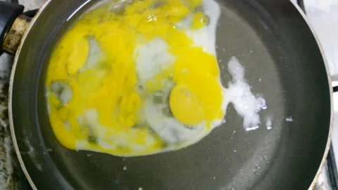 Preparation of fried eggs on a frying pan Stock Footage 75165674