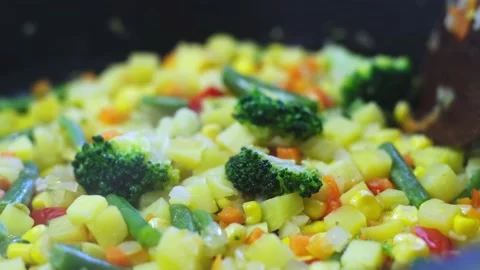 Preparation of frozen vegetable mixture, steaming food on a frying pan Stock Footage 201192889