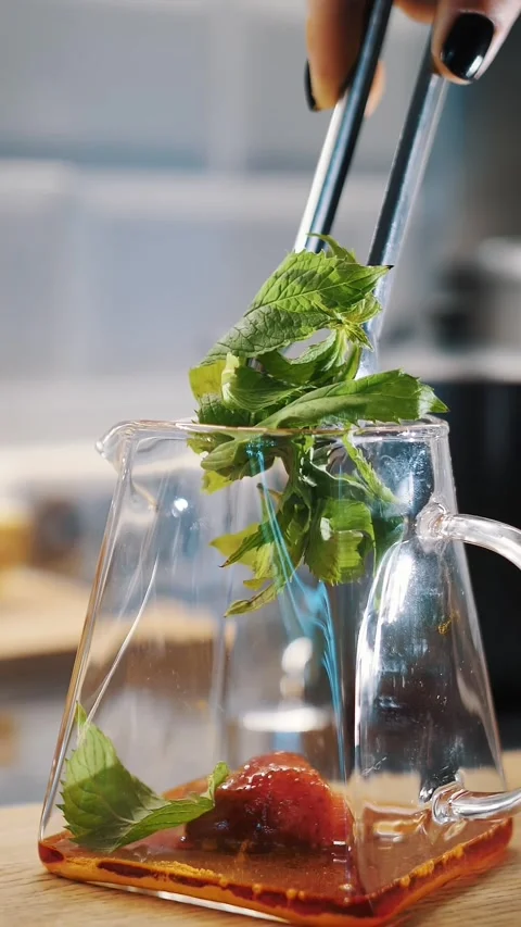 Preparation of fruit tea. tea drink. making tea. close-up. Add fresh green mint Stock Footage 323436786
