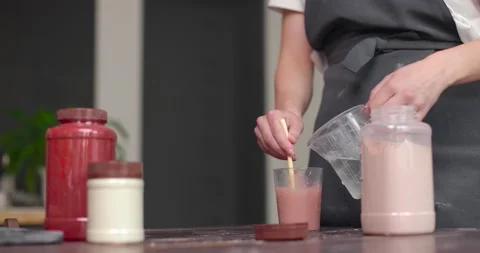 Preparation of glaze. Close up of womans hands stirring glaze in a jar. Stock Footage 155649422