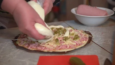 Preparation of homemade pizza on a light kitchen table, close-up shot. Stock Footage 75031585