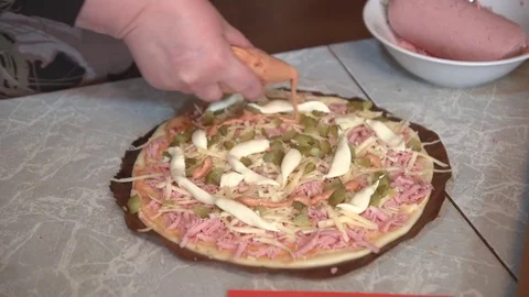 Preparation of homemade pizza on a light kitchen table, close-up shot. Vídeos de archivo 75031594