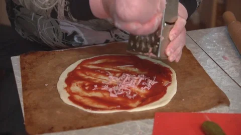 Preparation of homemade pizza on a light kitchen table, close-up shot. Stock Footage 75031614