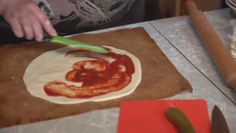 Preparation of homemade pizza on a light kitchen table, close-up shot. Stock Footage 75031617