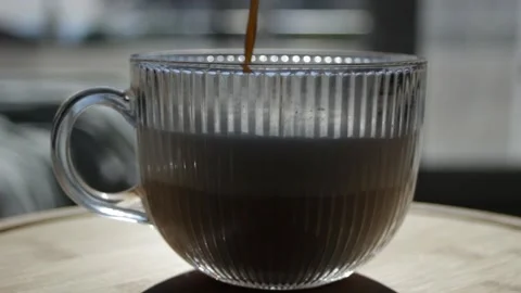 Preparation of invigorating coffee. Black coffee is poured into a beautiful Stock Footage 297461778