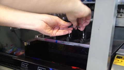 Preparation for the large-format inkjet printing press. Male hands worker merge Stock Footage 99525282