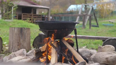 Preparation of a meal on open fire. Cooking dinner on wild hike outdoor. Hiking Stock Footage 220781374