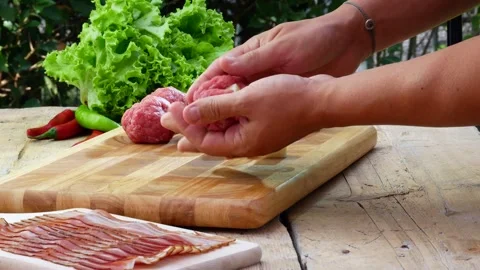 Preparation of meatballs stuffed with cheese and covered with bacon Stock Footage 242087920