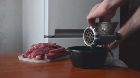 Preparation of minced meat. The guy turns a mechanical meat grinder. Stock Footage 159639189