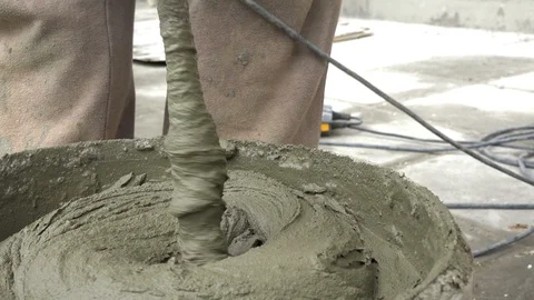Preparation of a mixture of a tile adhesive with mixer in a bucket Stock Footage 91248433