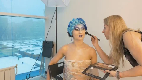 Preparation of the model for a photo shoot. The make-up artist covers the powder Video stock 84989470