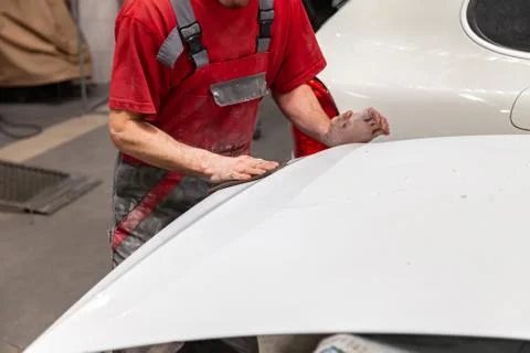 Preparation for painting a car element using emery sponge by a service techni Stock Photos