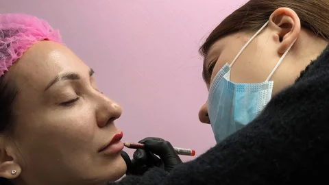 Preparation for permanent makeup. Draws a contour with a red pencil. Cosmetology Stock Footage 119892546