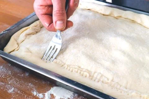 Preparation of pie for baking. Kitchen concept. Man's hand. Stock Photos