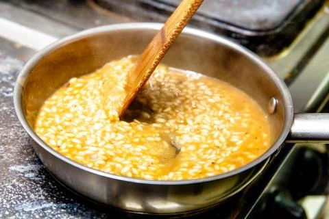 Preparation of risotto with mushrooms in the restaurant kitchen. Stock Photos