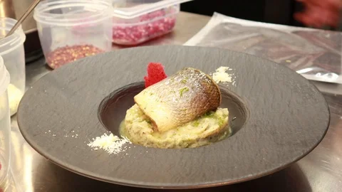 Preparation seabass fish and mashed potatoes. Serve on a black plate.The kitc 動画素材 129702156
