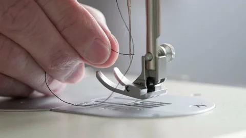 Preparation for sewing. Seamstress inserts thread in needle of sewing machine Video stock 203230234
