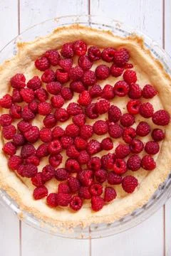 Preparation of shortbread pie with raspberries on a white wooden background, Stock Photos