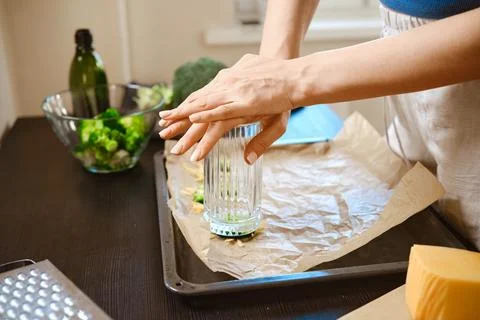 Preparation of smashed broccoli with cheese in a kitchen setting during dayti Stock Photos