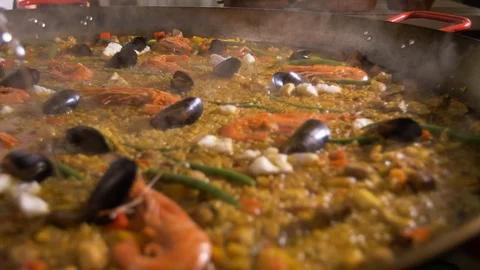 Preparation of Spanish paella. Adding olive oil to a mixture of rice, vegetables Video stock 89027673