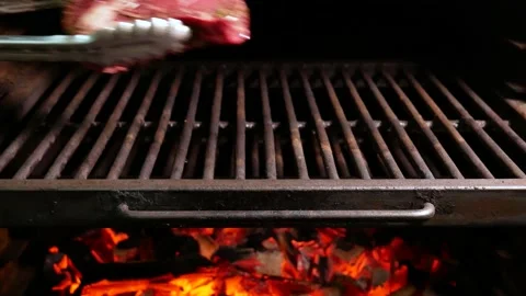Preparation of steak on the grate and coals. Chef making steak. Stock Footage 131718018