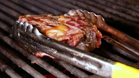 Preparation of steak on the grate and coals. Chef making steak. Stock Footage 131718323