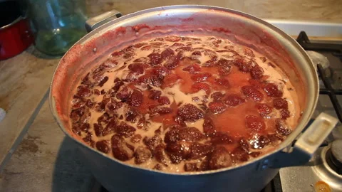 Preparation of strawberry jam. Cook jam. Homemade berry jam boils in a large Stock Footage 109330432