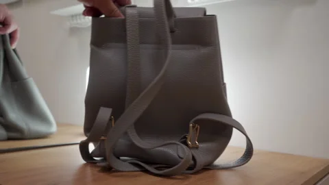 Preparation Underway: Leather Backpack Creaks and Jingles as it's Moved on Wood Stock Footage 320809273