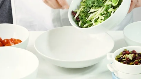 Preparation of vegetable salad step by step. Woman puts fresh green salad mix  Stock Footage 125124213