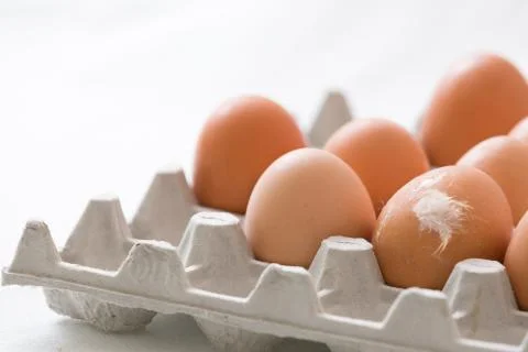 Preparations for Easter. Many light brown eggs in a paperbox. One egg with a Stock Photos