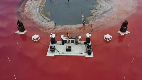Preparations for a massive beach party on the shore of a pink lake, aerial shot Stock Footage 144828104