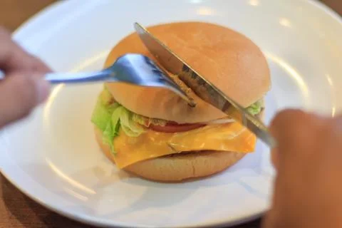 Prepare cutting burger in two halfs select focus, Holding cutting burger, Cut Stock Photos