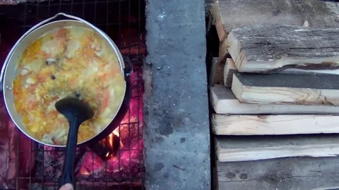 Prepare the dish on a bowler over the fire Stock Footage 74392560