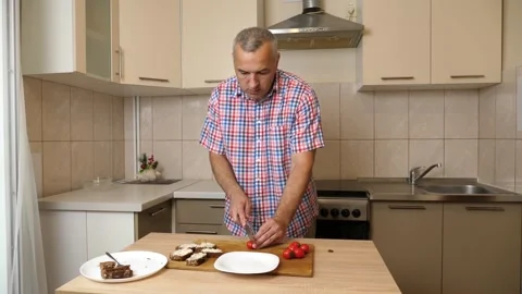 To prepare the dish, cherry tomatoes are cut in half with a knife. Stock Footage 282573394