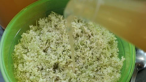 Prepare elder berry flower heads to making jam of it. Mixing apple juice into Stockbeeldmateriaal 109377024