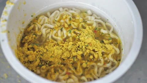 Prepare instant noodles boiled in hot water and adding spices Stock Footage 219418370