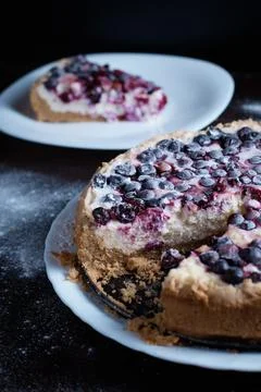 Prepared berry pie on the table in the kitchen the cook cuts a piece of a Stock Photos