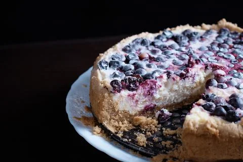 Prepared berry pie on the table in the kitchen the cook cuts a piece of a Stock Photos