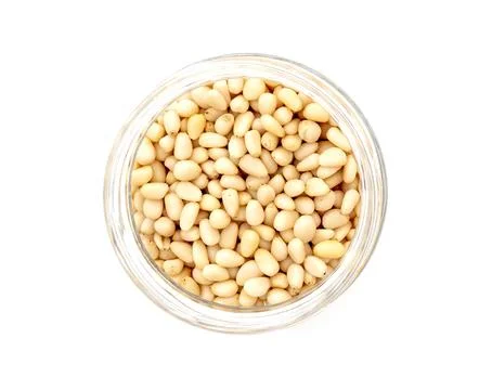 Prepared cedar pine nuts in round glass can isolated on white, top view Foto stock