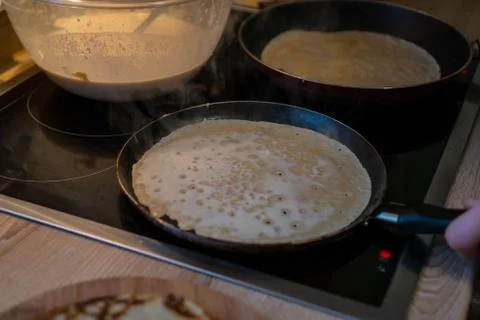 Prepares pancakes in the kitchen Stock Photos