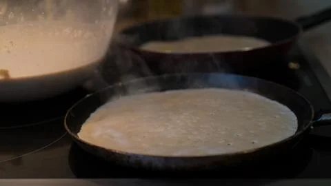 Prepares pancakes in the kitchen Stock Photos