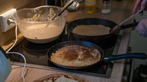Prepares pancakes in the kitchen Stock Photos